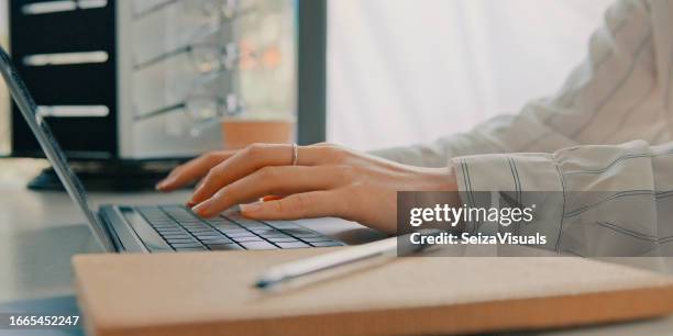 tippen von e-mails, schreibtisch und händen mit einem laptop für optometrie, kommunikation oder kontakt im internet. nahaufnahme, tisch und ein angestellter, eine sekretärin oder eine rezeptionistin mit einem computer für augenpflege oder planung - websurfen stock-fotos und bilder