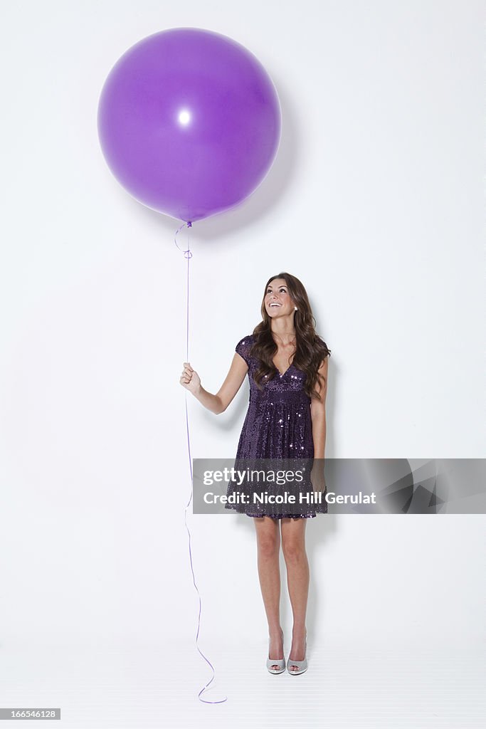 Young woman holding large balloon at party