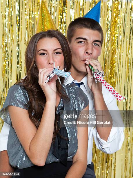 usa, utah, orem, portrait of young couple blowing horns at party - part horn blower stock pictures, royalty-free photos & images