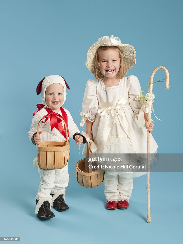 Portrait of girl (2-3) as Little Bo Peep with boy (12-17 months) as lamb for Halloween