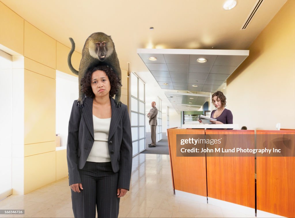 Monkey perched on businesswoman's shoulders