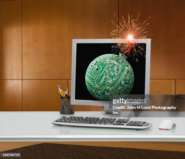 lit bomb fuse on office computer - ominous computer stock pictures, royalty-free photos & images