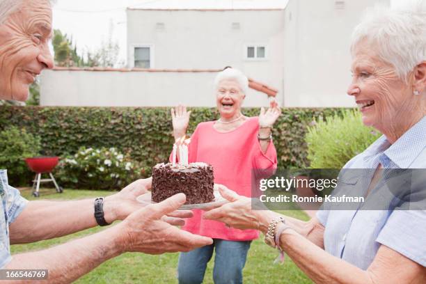 older caucasian friends celebrating birthday - los angeles garden party stock pictures, royalty-free photos & images