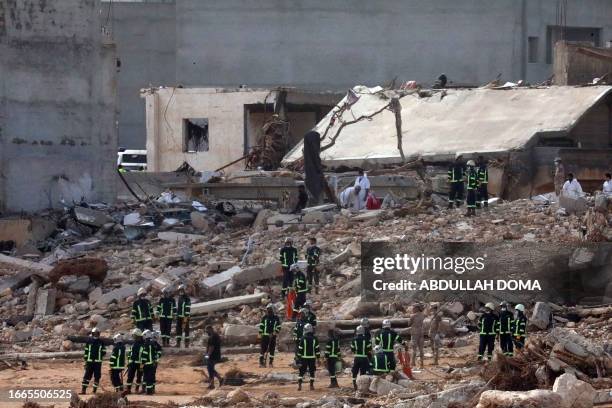 Rescuers gather amid the rubble of buildings damaged or levelled in flash floods after the Mediterranean storm "Daniel" hit Libya's eastern city of...