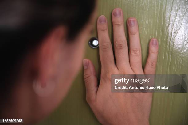 woman looking through a door viewfinder - peephole stock pictures, royalty-free photos & images