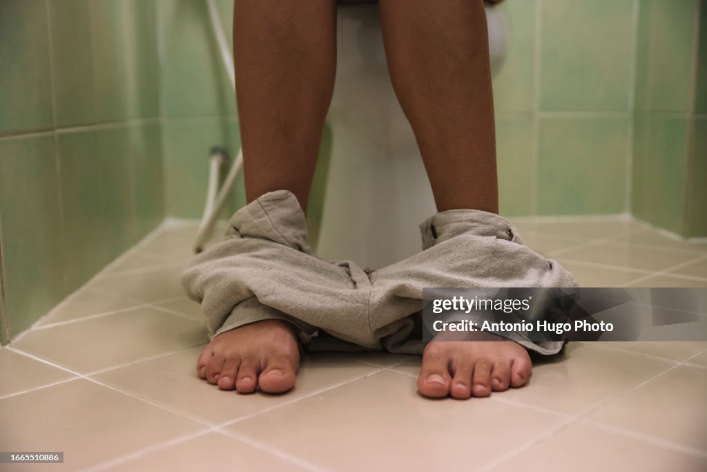 Close-up of a woman sitting on the toilet