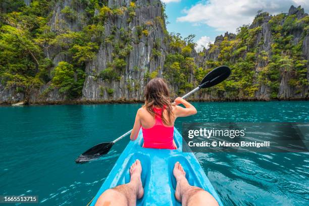 personal perspective of woman kayaking at twin lagoon, palawan, philippines - rowboat stock pictures, royalty-free photos & images