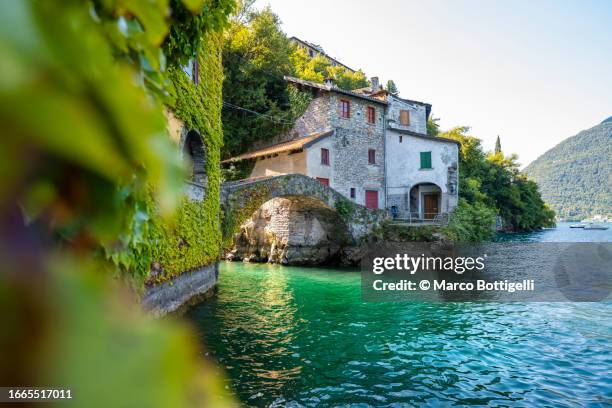 the old stone bridge over nesso gorge, lake como, italy - como italy stock pictures, royalty-free photos & images