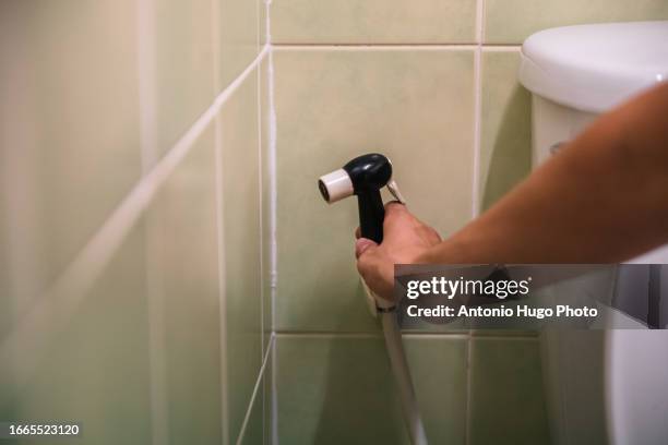 close-up of a hand grasping the toilet hose - woman hemorrhoids fotografías e imágenes de stock