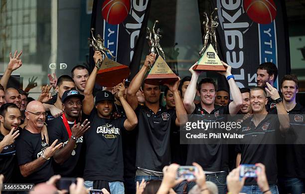 Bruton, Mika Vukona and Dillon Boucher of the New Zealand Breakers hold up their Championship trophys from the last three years during a homecoming...