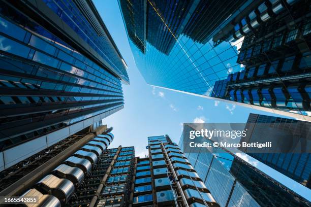 low angle view of shiny skyscrapers in london city, england, uk - wolkenkrabber stockfoto's en -beelden