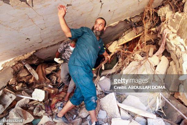 People search in the rubble of a building in a flash flood-damaged area in Derna on September 14, 2023. A global aid effort for Libya gathered pace...