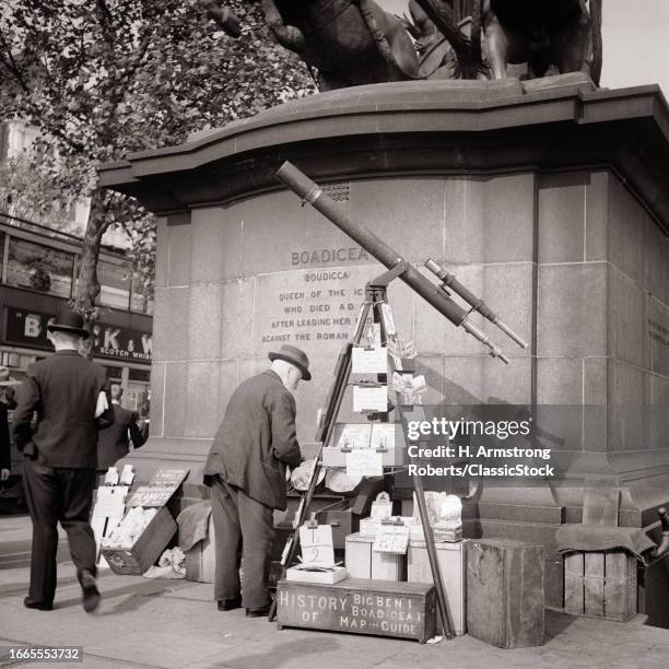 1930s Man vendor telescope for viewing big ben set up by statue of boadicea westminster bridge selling post cards maps london.