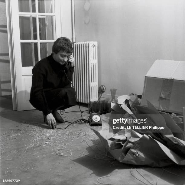 Francoise Sagan At Home On Grenelle Street. Françoise SAGAN téléphonant accroupie au milieu de cartons de papier kraft et de paille d'emballage dans...