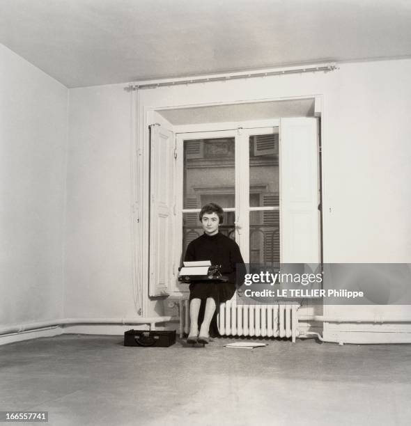 Francoise Sagan At Home On Grenelle Street. Françoise SAGAN assise devant sa fenêtre sur un radiateur sa machine à écrire sur les genoux dans son...