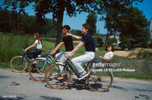 Close Up Hugues Aufray. Hugues AUFRAY et son épouse Hélène avec leurs deux filles Marie et Charlotte, faisant du vélo, en vacances en Normandie,...