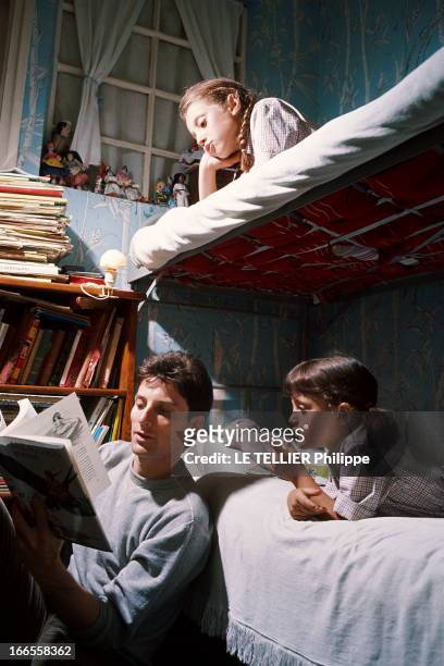 Close Up Hugues Aufray. Hugues AUFRAY dans la chambre de ses deux filles Charlotte et Marie, en train de leur lire une histoire. 1964.