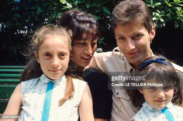Close Up Hugues Aufray. Hugues AUFRAY et sa femme Hélène assis sur un banc, avec leurs deux filles Charlotte et Marie , en juillet 1964.