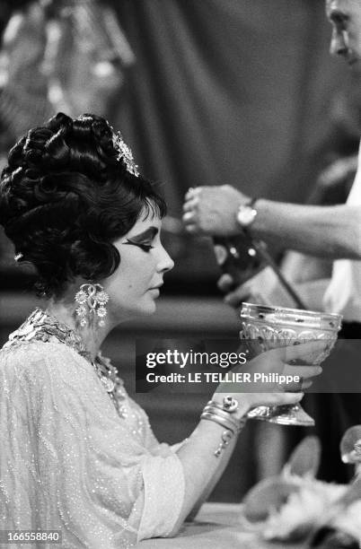 Shooting Of The Film 'Cleopatre' By Joseph L. Mankiewicz. Plan de profil d'Elizabeth TAYLOR tenant une coupe, lors du tournage d'une scène de banquet...