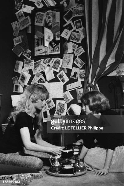 Brigitte Bardot And Her Sister Mijanou. Brigitte BARDOT et sa soeur Mijanou devant une tasse de thé. Avril 1958.