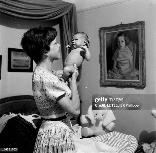 Close-Up Of Cecile Aubry And Son Mehdi. En France, en juin 1956, dans une chambre, portrait de Cécile AUBRY les cheveux courts, tenant son fils MEHDI...