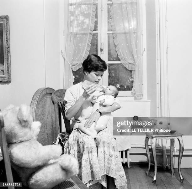 Close-Up Of Cecile Aubry And Son Mehdi. En France, en juin 1956, portrait de Cécile AUBRY les cheveux courts, assise avec son fils MEHDI bébé dans...