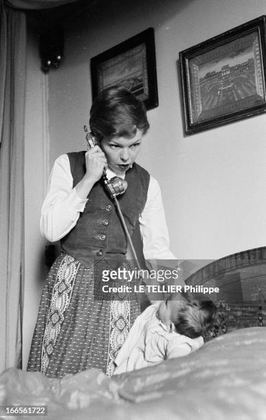 Close-Up Of Cecile Aubry And Son Mehdi. En France, en mai 1957, portrait de Cécile AUBRY dans une chambre, les cheveux courts, téléphonant en...