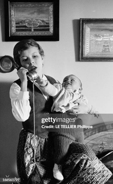 Close-Up Of Cecile Aubry And Son Mehdi. En France, en mai 1957, portrait de Cécile AUBRY les cheveux courts, téléphonant dans une chambre, tenant...