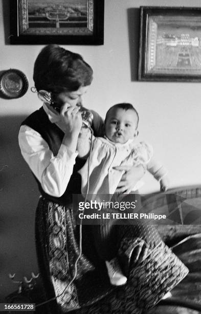 Close-Up Of Cecile Aubry And Son Mehdi. En France, en mai 1957, portrait de Cécile AUBRY les cheveux courts, téléphonant dans une chambre, tenant...