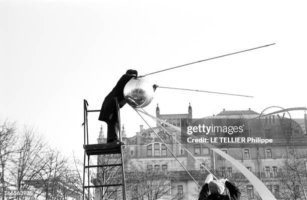 Moscow Winter. A Moscou, le 16 Novembre 1959, reportage sur la ville: un Moscovite, monté au sommet d'un escabeau sur roulettes maintenu par trois...