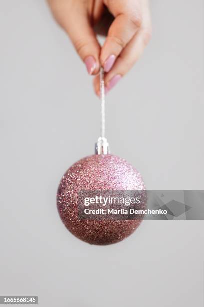 hand with pink glitter christmas ball and pink gel fingernails - christmas ornament stock pictures, royalty-free photos & images