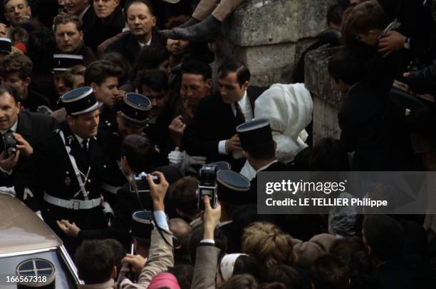 The Marriage Of Johnny Hallyday And Sylvie Vartan In Loconville. Loconville - 12 avril 1965 - De dos protégée par des gendarmes, la chanteuse Sylvie...