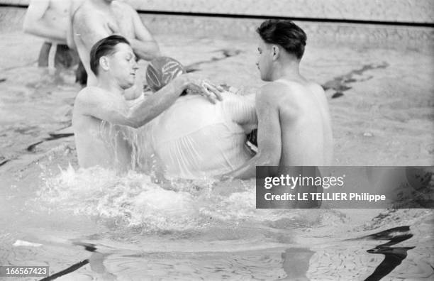 Witnesses Of Jehovah. En France, le 6 août 1955, dans une piscine, lors d'une assemblée des Témoins de Jéhovah, deux hommes dans un bassin baptisant...