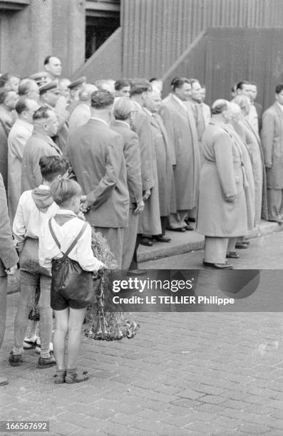 Official Visit Of Nikita Khrushchev To Berlin. En Allemagne de l'Est, à Berlin Est, sur un trottoir, des hommes, en costume, de dos, attendant...