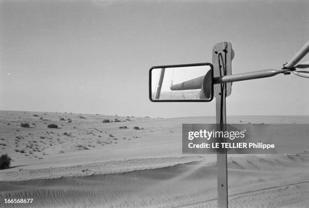 Construction Of Pipe Line. En 1958, dans le désert du Sahara, vue dans le rétroviseur d'un camion, d 'un troncon de canalisations sur la trajectoire...