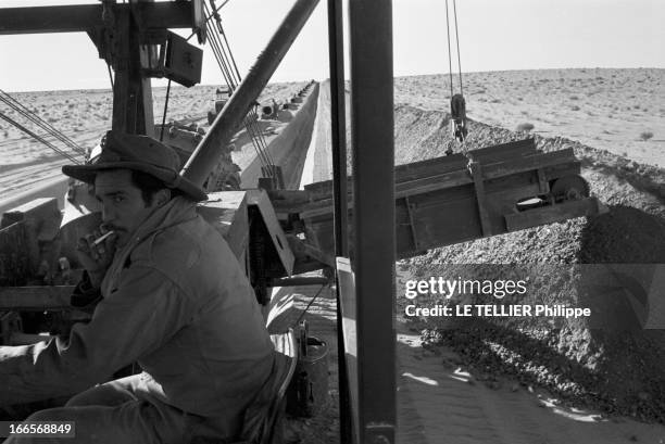 Construction Of Pipe Line. En 1958, dans le désert du Sahara, un conducteur de machine fumant sur son engin, sur le chantier d'un pipeline mis en...