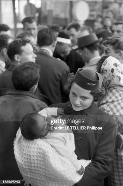 Josephine Baker Adopts A Tenth Child. En France, le 25 avril 1959, dans un aéroport, une hôtesse de l'air tient dans ses bras Mara, le 10e enfant...