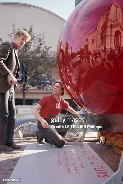 The 'Souffles' A Works Of Artist Gerard Fromanger. A Paris, en 1968, Gérard FROMANGER, accroupi devant une demi-sphère en plastique, sur une pancarte...