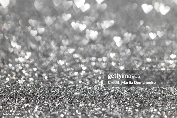 silver sparkling glitter hearts bokeh lights background - silver metal stock pictures, royalty-free photos & images