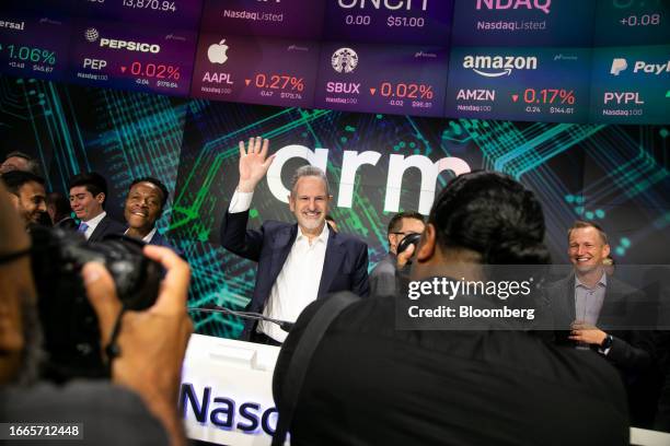 Rene Haas, chief executive officer of Arm Ltd., center, rings the opening bell with guests during the company's IPO at the Nasdaq MarketSite in New...