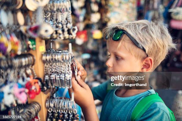 little boy browsing souvenirs at street market in pisa - souvenir keychain stock pictures, royalty-free photos & images
