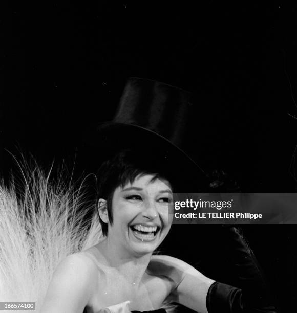 Portrait Of Zizi Jeanmaire. Octobre 1960. La danseuse-chanteuse Zizi JEANMAIRE riant. Elle est vétue d'un bustier noir, de gants noirs, d'un chapeau...