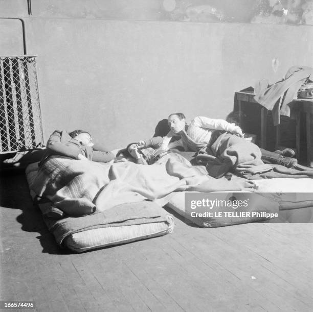 The Action Of Abbe Pierre. Ile-de-France - Février 1954 - L'Association Emmaüs: un couple et leur fille sans abri, allongés au sol sur des matelas,...