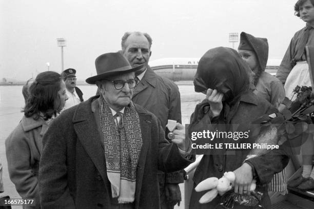 Close-Up Of Dany Saval. Paris - 29 et 30 mars 1961 - L'actrice Dany SAVAL entourée de personnes non identifiée sur la piste d'un aéroport, se cachant...