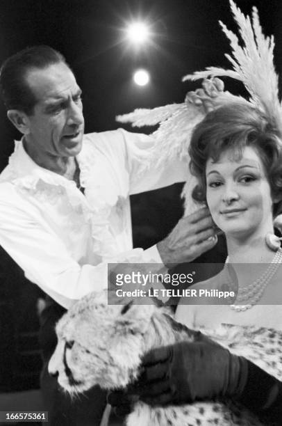At The Antonio Circus. Paris- 7 Octobre 1959- Au cirque ANTONIO, le Coiffeur posant des plumes sur la chevelure d'une jeune femme en robe longue à...
