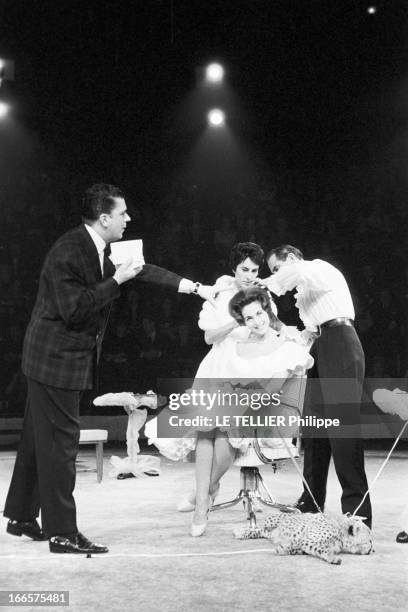 At The Antonio Circus. Paris- 7 Octobre 1959- Au cirque ANTONIO, le Coiffeur coiffant une jeune femme en robe blanche à volants, assise sur un...