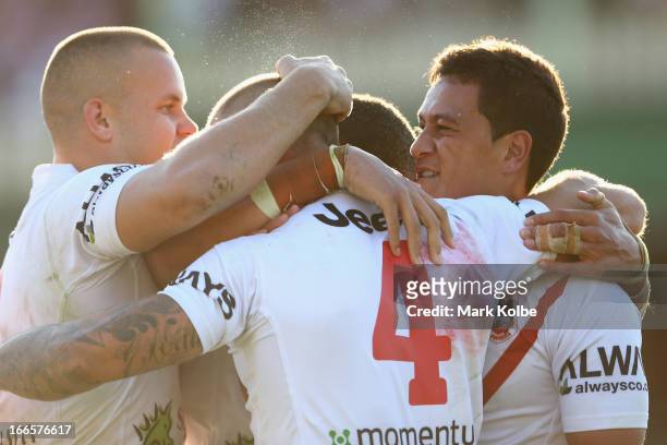 Matt Cooper of the Dragons celebrates with his team mates after scoring a try during the round six NRL match between the Wests Tigers and the St...