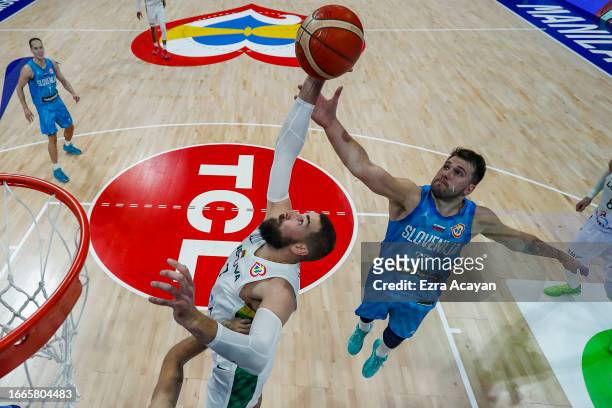 Jonas Valanciunas of Lithuania and Luka Doncic of Slovenia vie for the ball during the FIBA Basketball World Cup Classification 5-8 game between...