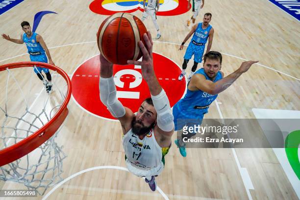 Jonas Valanciunas of Lithuania dunks the ball against Luka Doncic of Slovenia during the FIBA Basketball World Cup Classification 5-8 game between...