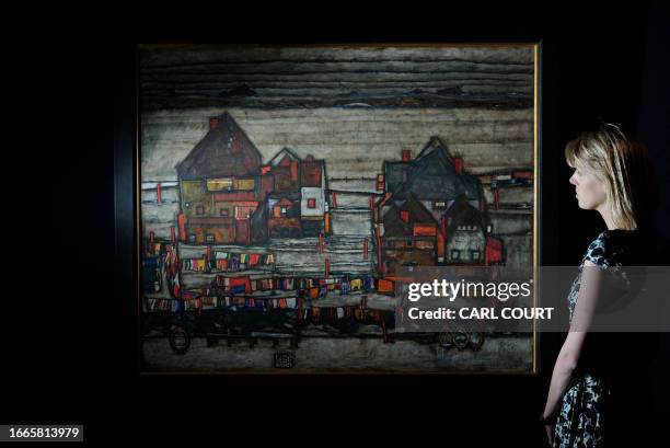 Sotheby's employee poses next to a painting entitled 'Hauser Mit Bunter Wasche - Houses With Laundry by Austrian artist Egon Schiele at Sotheby's...